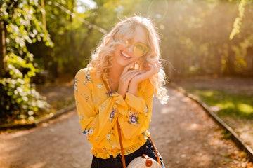 Smiling woman in nature, surrounded by greenery, representing positivity, inspiration, and a healthy, motivated mindset for creativity and well-being.
