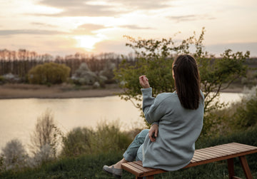 A calm woman standing alone outdoors at sunset, practicing self-care and emotional boundaries, representing radical self-respect and personal growth.