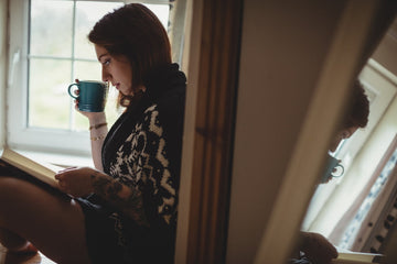 How to reinvent yourself: woman sitting and reading for inspiration after feeling stuck or out of place.