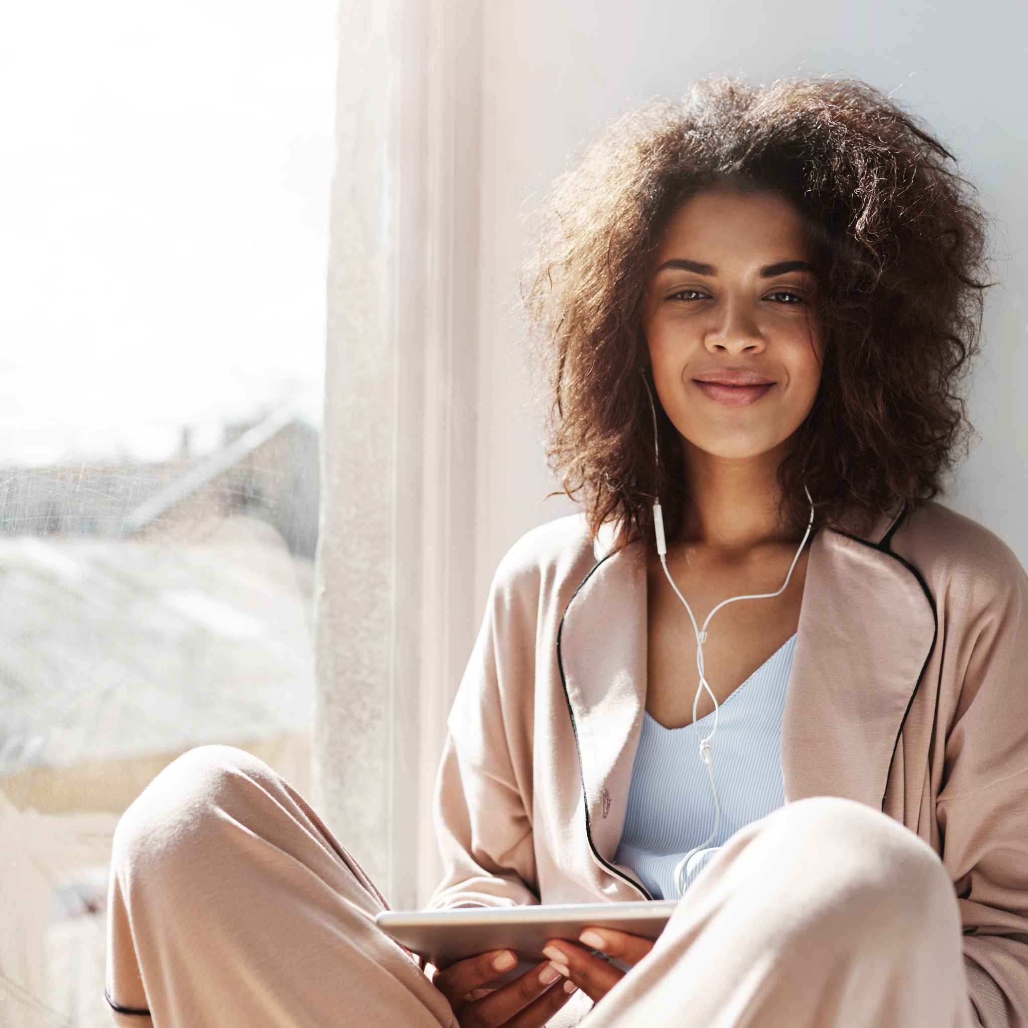 Confident woman relaxing with a cup of tea, embracing self-care, self-love, and emotional wellness in a cozy, peaceful setting.