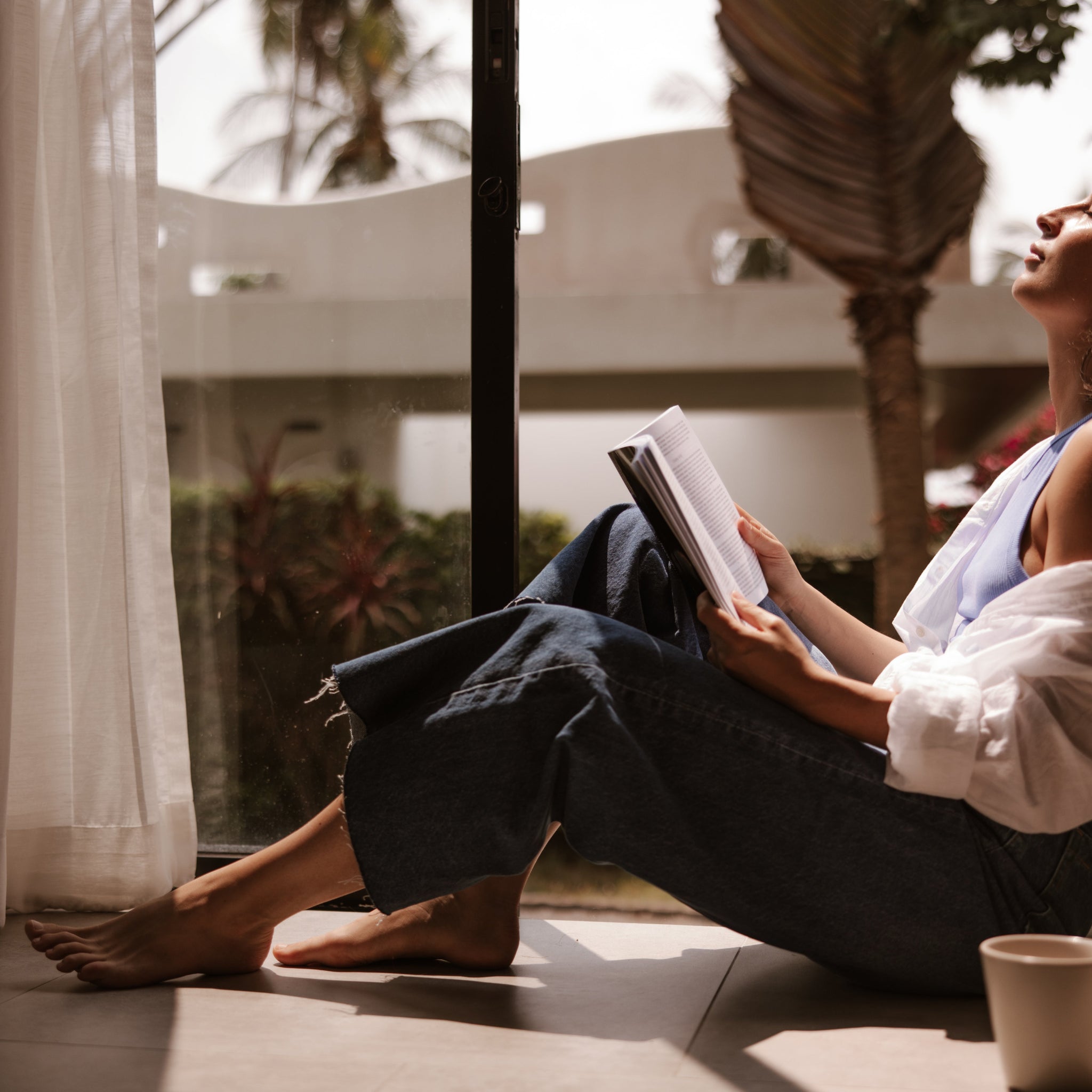 Relaxed woman embracing slow living, simple daily habits at home, showing how restful routines and 'lazy' self-care habits can boost mental wellness.