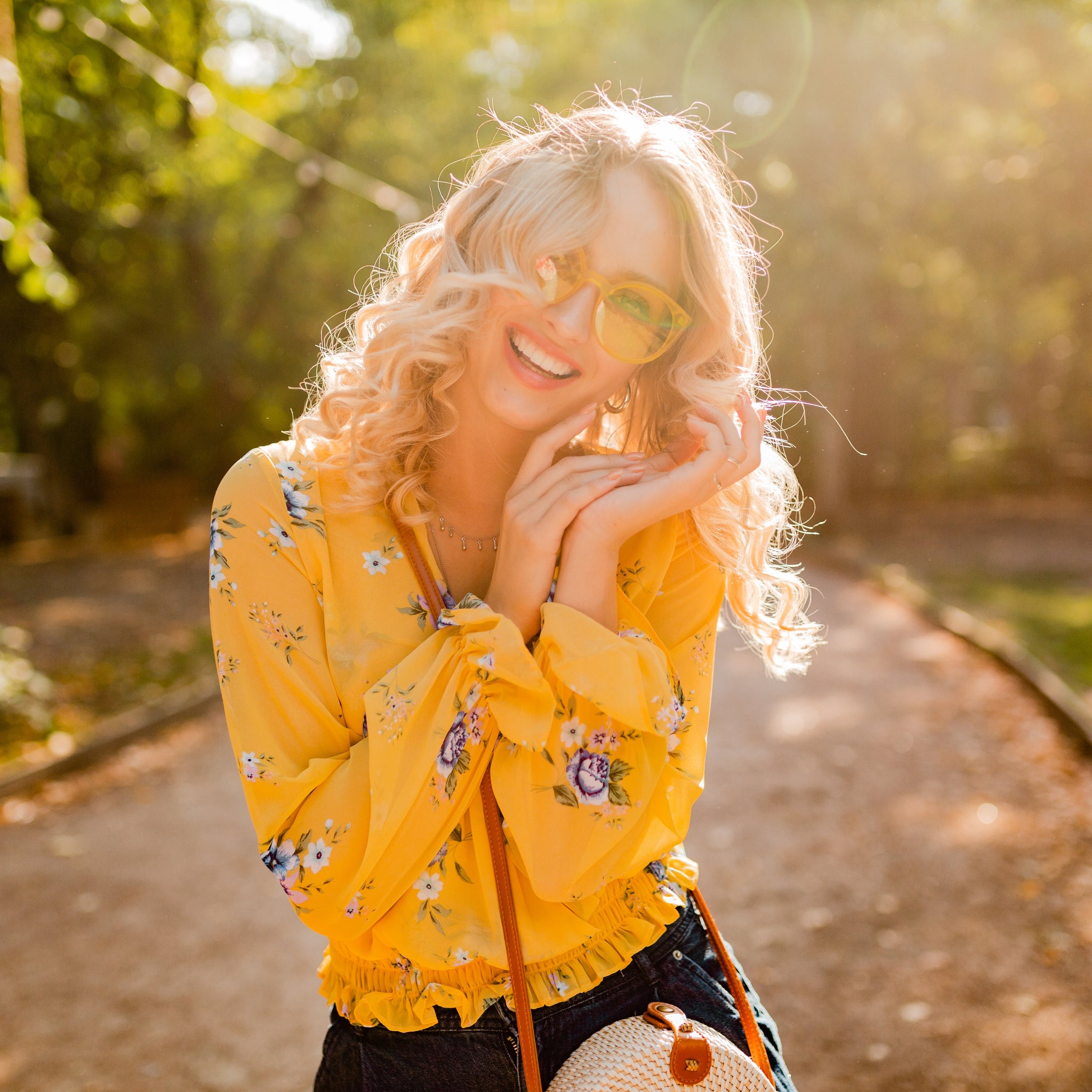 Smiling woman in nature, surrounded by greenery, representing positivity, inspiration, and a healthy, motivated mindset for creativity and well-being.