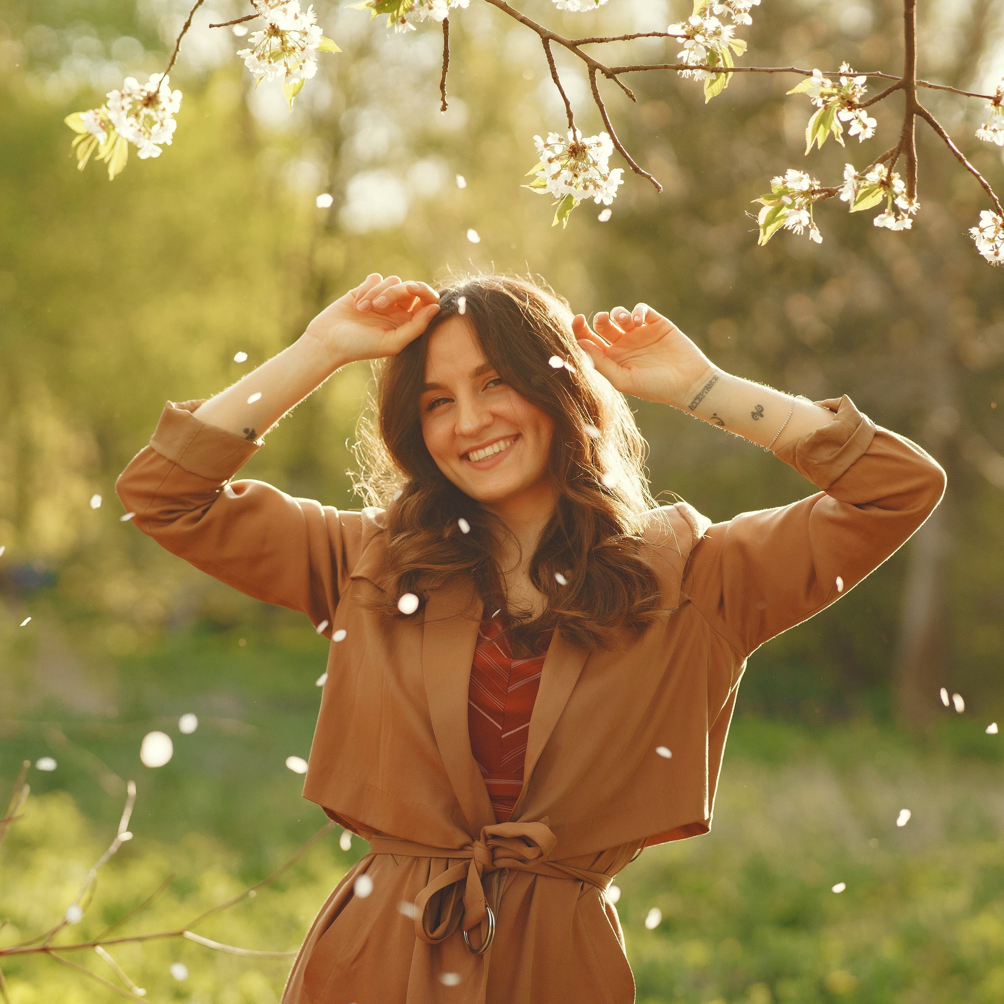 Smiling woman in nature focusing on the good, practicing mindfulness, positivity, and intentional living for emotional wellness.