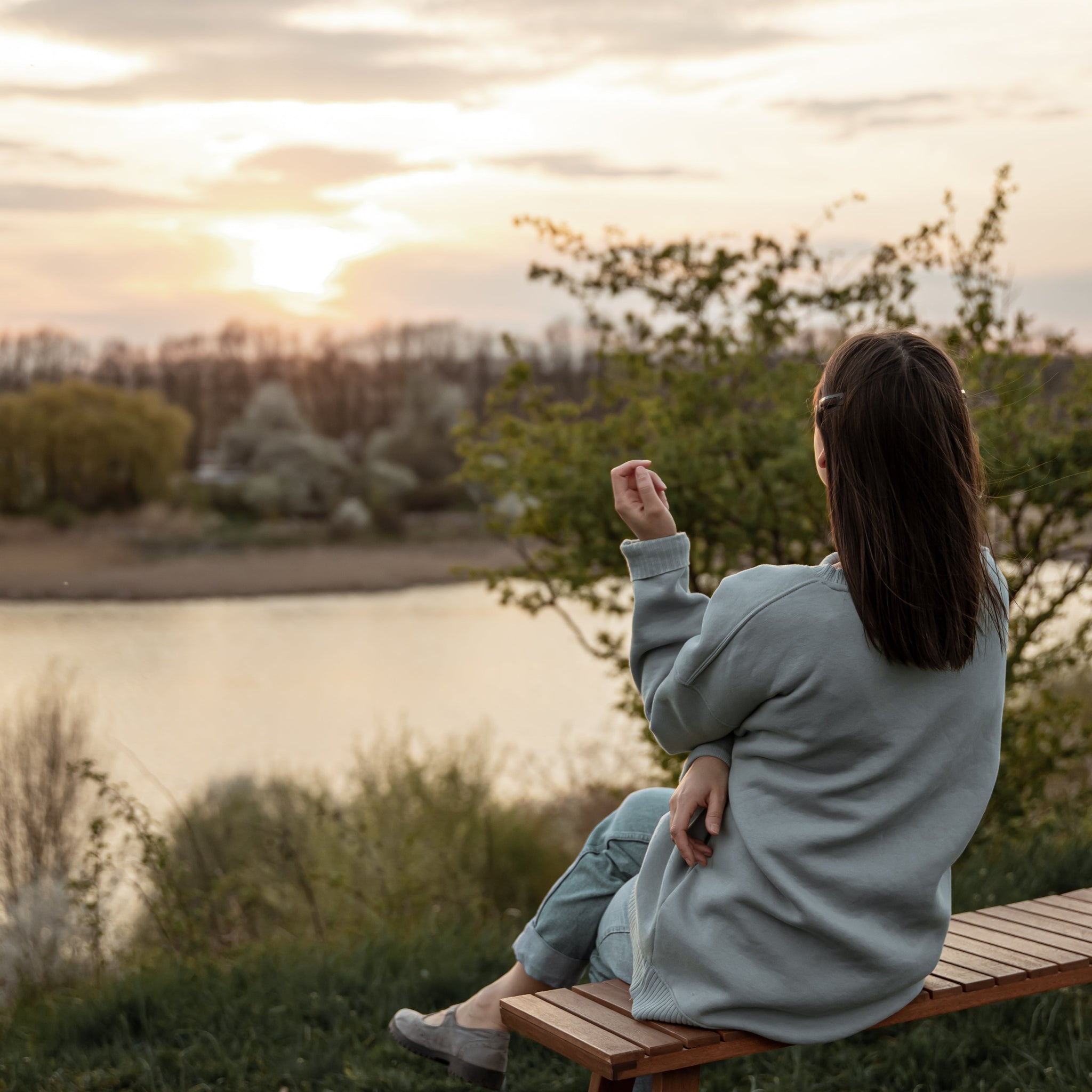 A calm woman standing alone outdoors at sunset, practicing self-care and emotional boundaries, representing radical self-respect and personal growth.